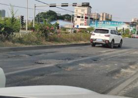灵山这个十字路口红绿灯处坑洼不平，司机注意减速通行！